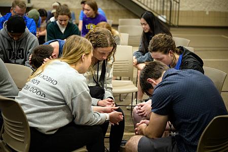 Students pray during an InterVarsity regional gathering